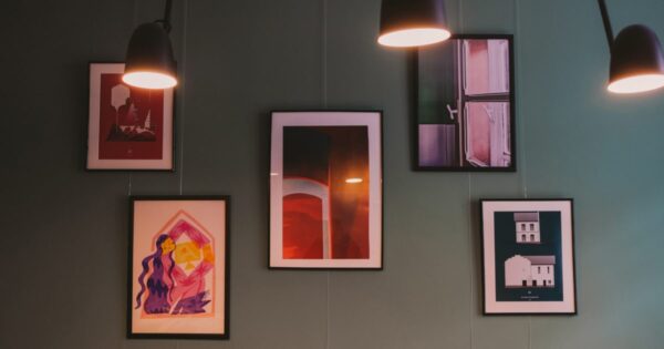 Paintings on the wall with lights from the top